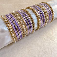 2 Small stacks of Antique Gold bangles with Pearl and Clear stonework details finished with pretty purple shades and our favourite Daisy Bangle in the centre to add that sparkle. Ready to Ship! Packed in small box ( no roll ) Purple Bangles Set, Purple Bangles, Lavender Color Dress, Antique Gold Bangles, Colorful Bangles, Purple Shades, Bridal Choker, Purple Daisy, The Bangles