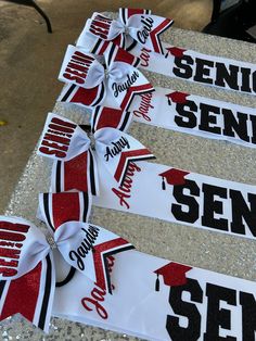 three red and white ribbons with the words senior sem on them are sitting next to each other