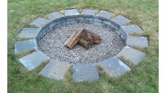 a fire pit made out of stones in the grass