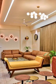 a living room with couches, tables and lamps on the ceiling is lit by recessed lights