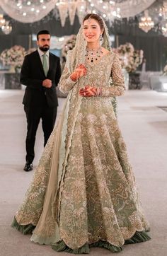 a woman in a wedding dress standing next to a man