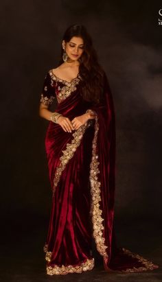 a woman in a red velvet sari with gold embroidery on the shoulders and shoulder