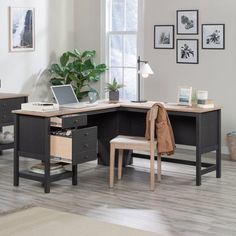 a corner desk with a laptop on it and a chair in front of the desk