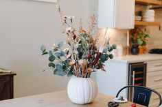 a vase filled with flowers sitting on top of a wooden table