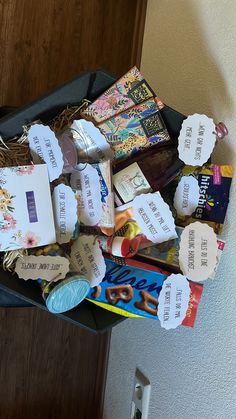 an open suitcase filled with lots of different types of paper and crafting supplies on top of a wooden floor