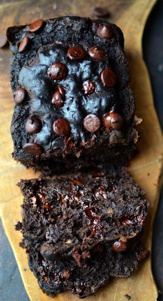 two chocolate brownies are sitting on a cutting board