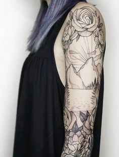 a woman with blue hair and tattoos on her arm