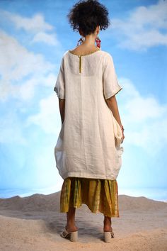 Ivory linen boho tunic dress with thread embroidery. Comes with a yellow cotton long frilled inner with tie-dye print.
Components: 2
Pattern: Printed, Embroidered
Type Of Work: Tie-Dye, Thread
Neckline: Round
Sleeve Type: Dress : Half, Inner : Sleeveless
Fabric: Dress : Linen, Inner : Cotton
Color: Ivory, Yellow
Other Details: 
Closure : Back button
Note : Earrings worn by the model are not for sale.
Occasion: Work - Aza Fashions White Tunic Lagenlook Dress, White Lagenlook Tunic Dress, Peasant Linen Tunic Dress, White Bohemian Dress With Natural Dye, White Bohemian Linen Dress Made Of Ramie, White Bohemian Ramie Linen Dress, Bohemian Linen Tunic Dress, White Linen Peasant Dress, Beige Bohemian Short Sleeve Linen Dress