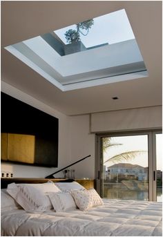 a bedroom with a skylight above the bed