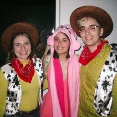 three people dressed up in costumes and hats posing for a photo with one woman wearing a cowgirl costume