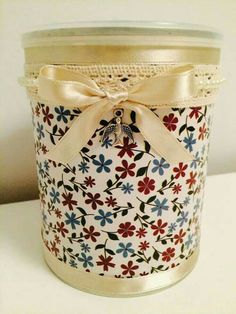 a jar with a bow on it sitting on top of a white table next to a wall