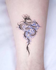 a woman's foot with a dragon tattoo on the left side of her leg