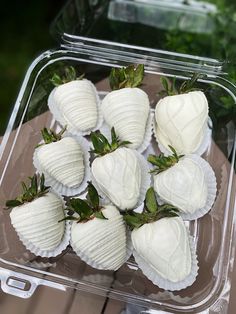 a plastic container filled with white chocolate covered strawberries