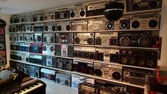 a room filled with lots of old radio's and musical equipment on display in front of a wall