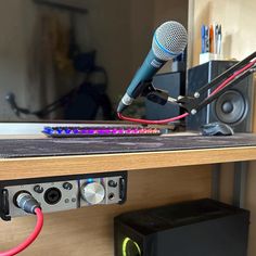 a microphone is sitting on top of a shelf next to some other electronics and sound equipment