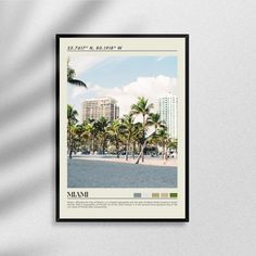 a poster hanging on the wall with palm trees and buildings in the background, miami