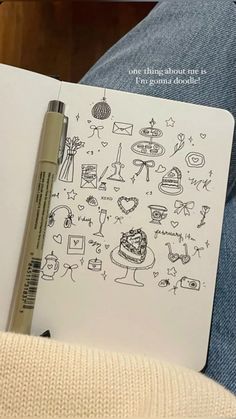 a pen is sitting on top of an open notebook with doodles and drawings in it