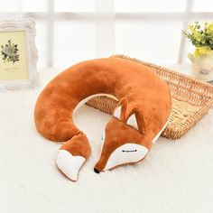 a stuffed animal pillow that is shaped like a fox