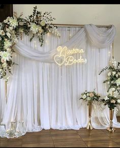 the backdrop is decorated with white flowers and greenery