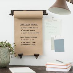 a brown piece of paper hanging on a wall next to a lamp and some books