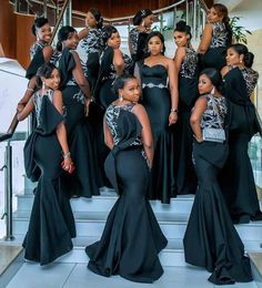 a group of women in black dresses standing on stairs