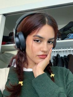 a young woman wearing headphones and looking at the camera