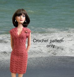 a doll is standing on the beach next to the ocean