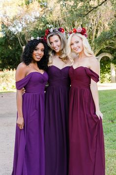 three women in long dresses standing next to each other