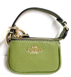 Coach Mini Nolita Bag Charm • IM/Olive Green • New with Tag! Features: • Refined pebble leather • Attached split keyring • Dogleash clip closure • Mini logo charm • Mini top handle • Zip top closure • Fully lined • Goldtone hardware • Measures: 3.25" x 2" x 1" • Handle drop: 2.25" • Style #: CC313 • MSRP $138.00 • Imported • New with tags Mini Logo, Mini Logos, Mini Top, Charm Keychain, Coach Accessories, Zip Top, Pebbled Leather, Mini Bag, Olive Green