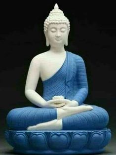 a buddha statue sitting on top of a blue cushion