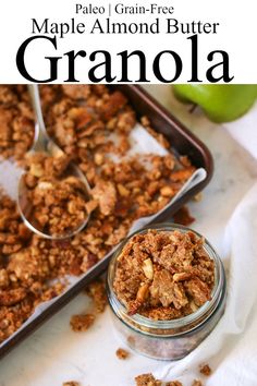 a close up of granola in a glass jar on a table with an apple