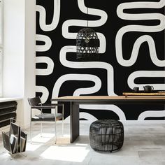 a black and white wallpaper with an abstract design in the center, next to a dining room table