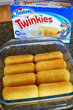 several pieces of bread in a glass dish next to a box of twinkies