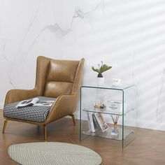 a chair sitting next to a glass table on top of a hard wood floor in front of a white wall