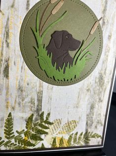 a close up of a card with a dog in the grass and leaves on it