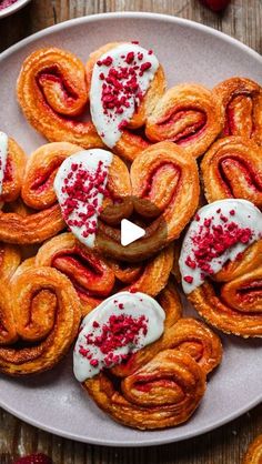 several pastries on a plate with red sprinkles and white icing