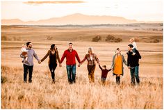 a group of people holding hands walking across a field