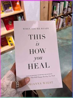 a person holding up a book in front of a bookshelf with the title, when you're ready this is how you heal