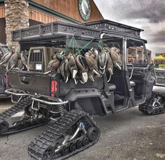 a jeep with skis attached to it parked in front of a building next to another vehicle