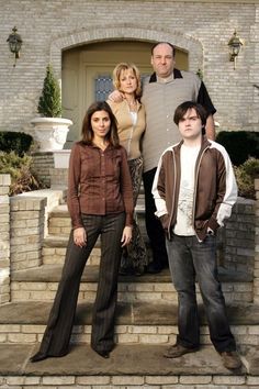 the cast of modern family poses for a photo in front of their home, which is decorated with brick and stone steps