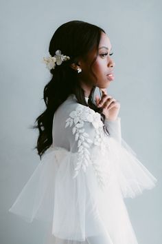 a woman wearing a white dress with flowers in her hair