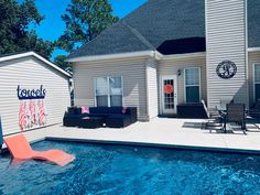 a house with a swimming pool and lounge chairs