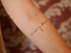 a person with a tattoo on their arm that says, strength of grace and the cross