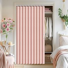 a bedroom with pink and white striped curtains in the door way, next to a bed