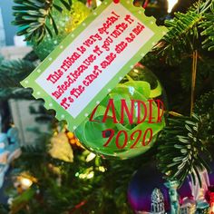 a christmas ornament hanging from the side of a tree with a message on it