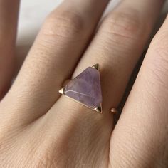 Treat yourself to this elegant and unique triangle-shaped amethyst ring. The adjustable band makes it perfect for any finger size, while the amethyst stone provides you with all the benefits of this powerful crystal. With its deep purple hue, this ring is sure to add a touch of luxury and new age style to your look.

 

 	Natural Stone - Ethically Sourced
 	Meditation & Calm Dreams
 	Positive transformation & Inner peace
 	2 Days Free Shipping from the USA Triangle Stone Ring, Power Crystals, Amethyst Jewelry, Purple Hues, Crystal Shop, Triangle Shape, Amethyst Stone, Amethyst Gemstone, Amethyst Ring