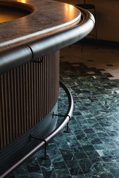 a curved counter top sitting next to a tiled floor