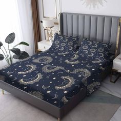 a bed with blue and gold sheets in a room next to a plant on the floor