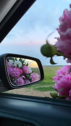 a car's rear view mirror with pink flowers in it