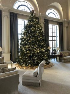 a living room with a large christmas tree in it